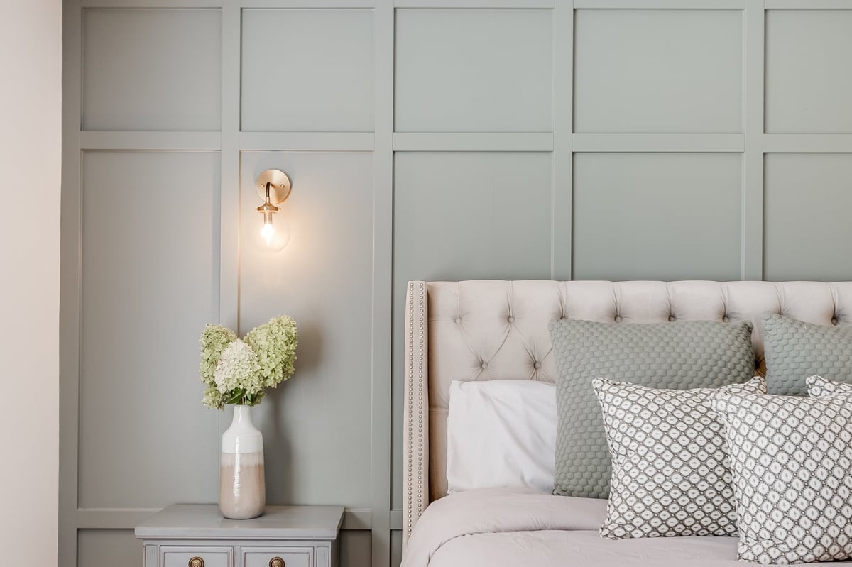 Warm, cozy bedroom with soft green tones, freshly cleaned and inviting